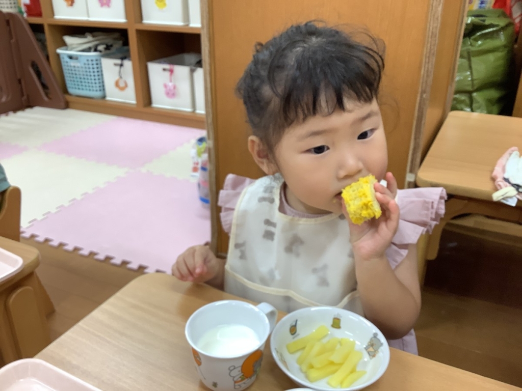 とうもろこしを食べる園児