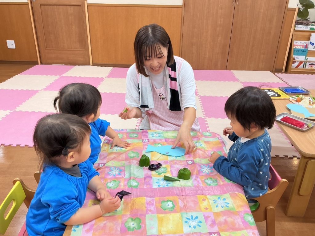 野菜スタンプを保育者が見せる様子