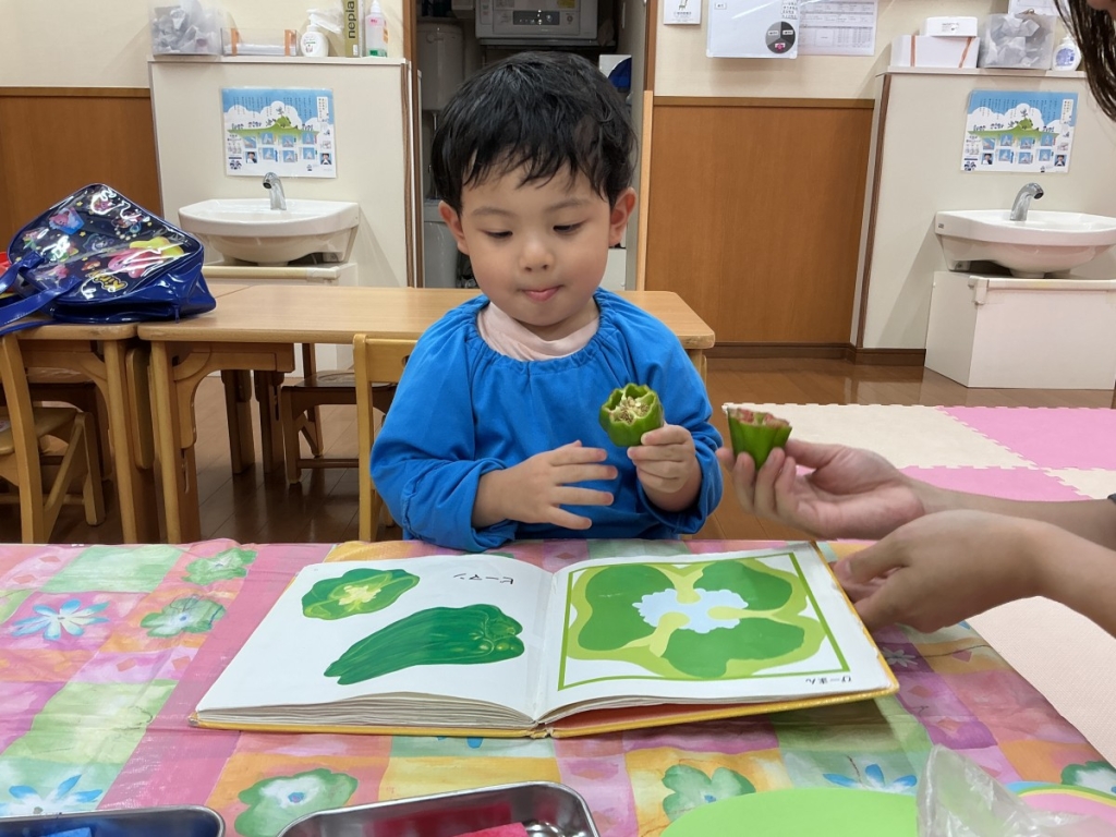 野菜と絵本を見比べる園児
