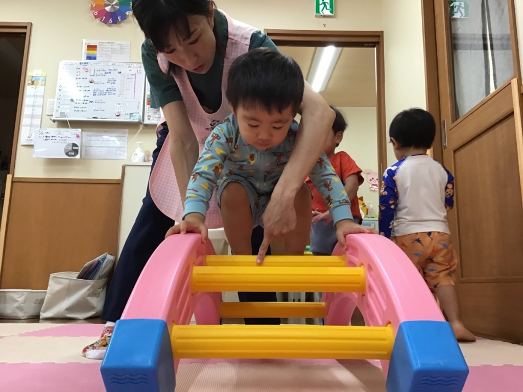 はしごを渡る園児