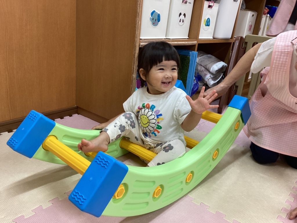はしごをバランスボードにして遊ぶ園児