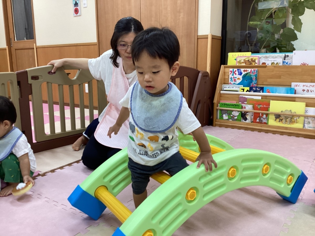 はしごを跨いで渡る園児