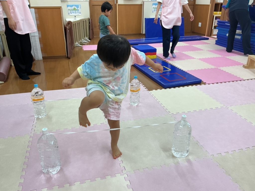 8月運動プログラムの様子(くじら組・ゴム跨ぎ)