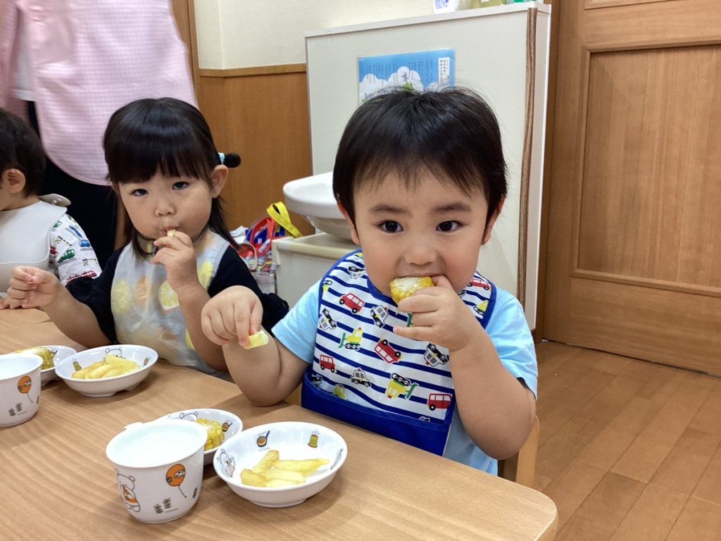 とうもろこしを食べる園児