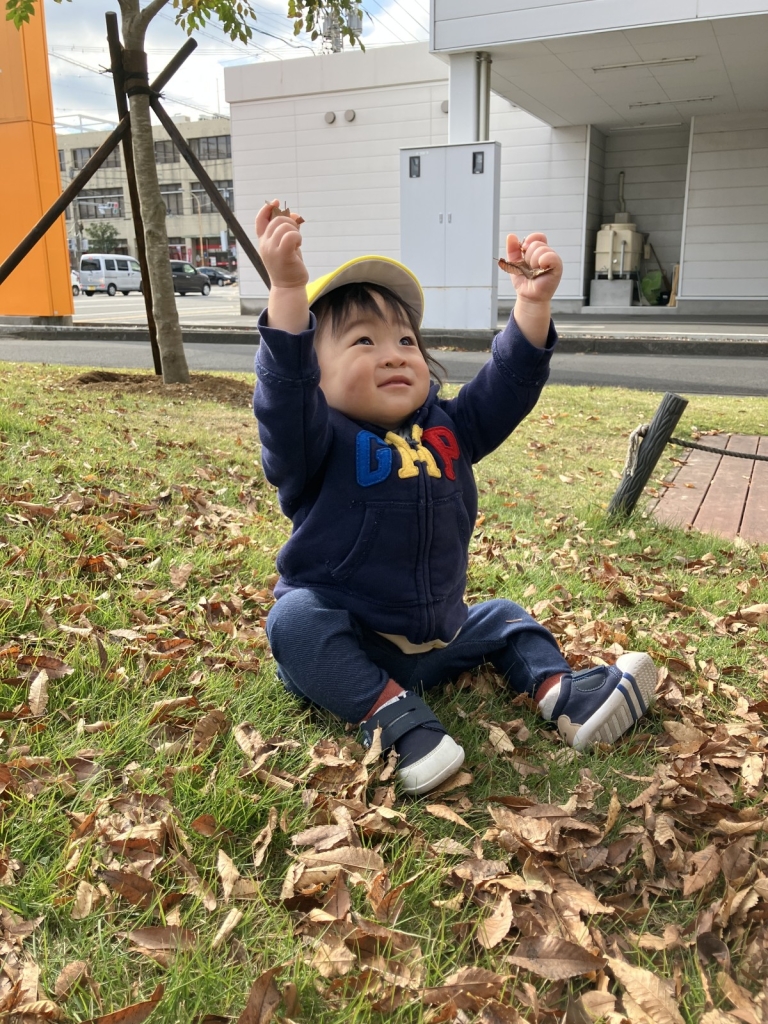 落ち葉で遊ぶ0歳児